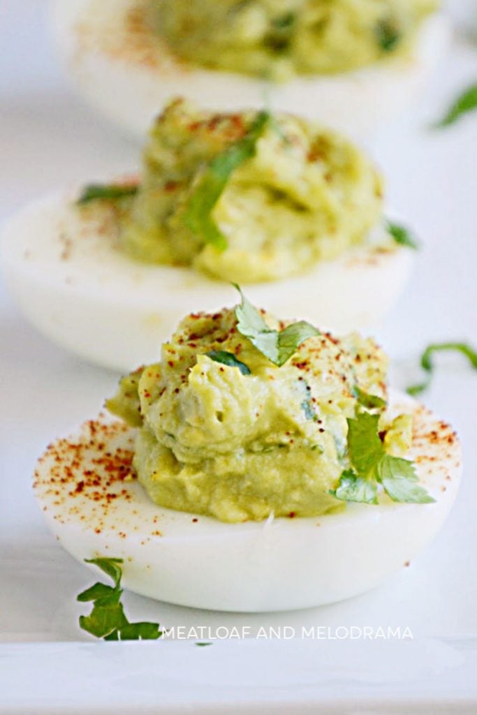 guacamole deviled eggs on a serving tray
