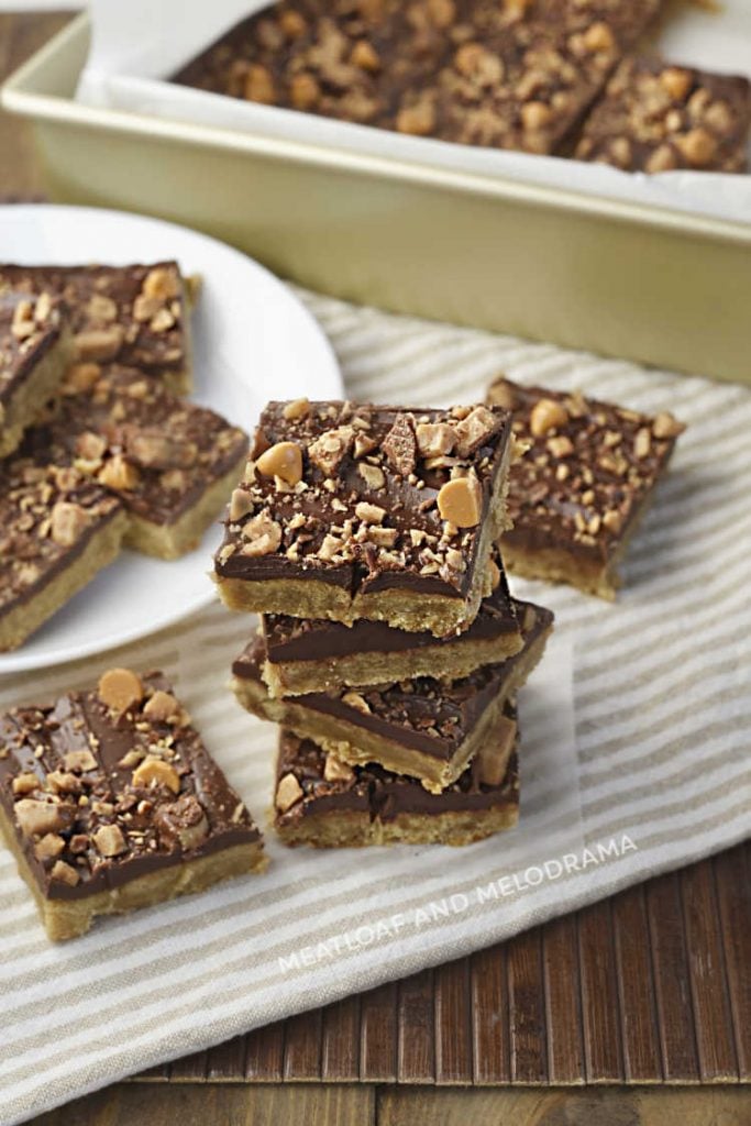 toffee bar cookies with chocolate and butterscotch chips stacked up on a napkin