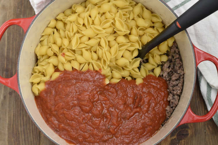 marinara sauce with shell pasta and ground beef in dutch oven