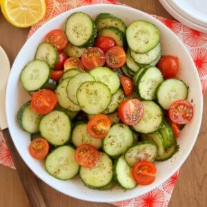 cucumber and tomato salad in a white serving bowl.
