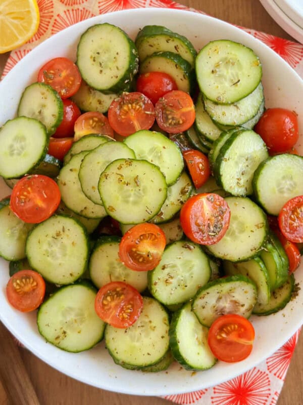 cucumber and tomato salad in a white serving bowl.