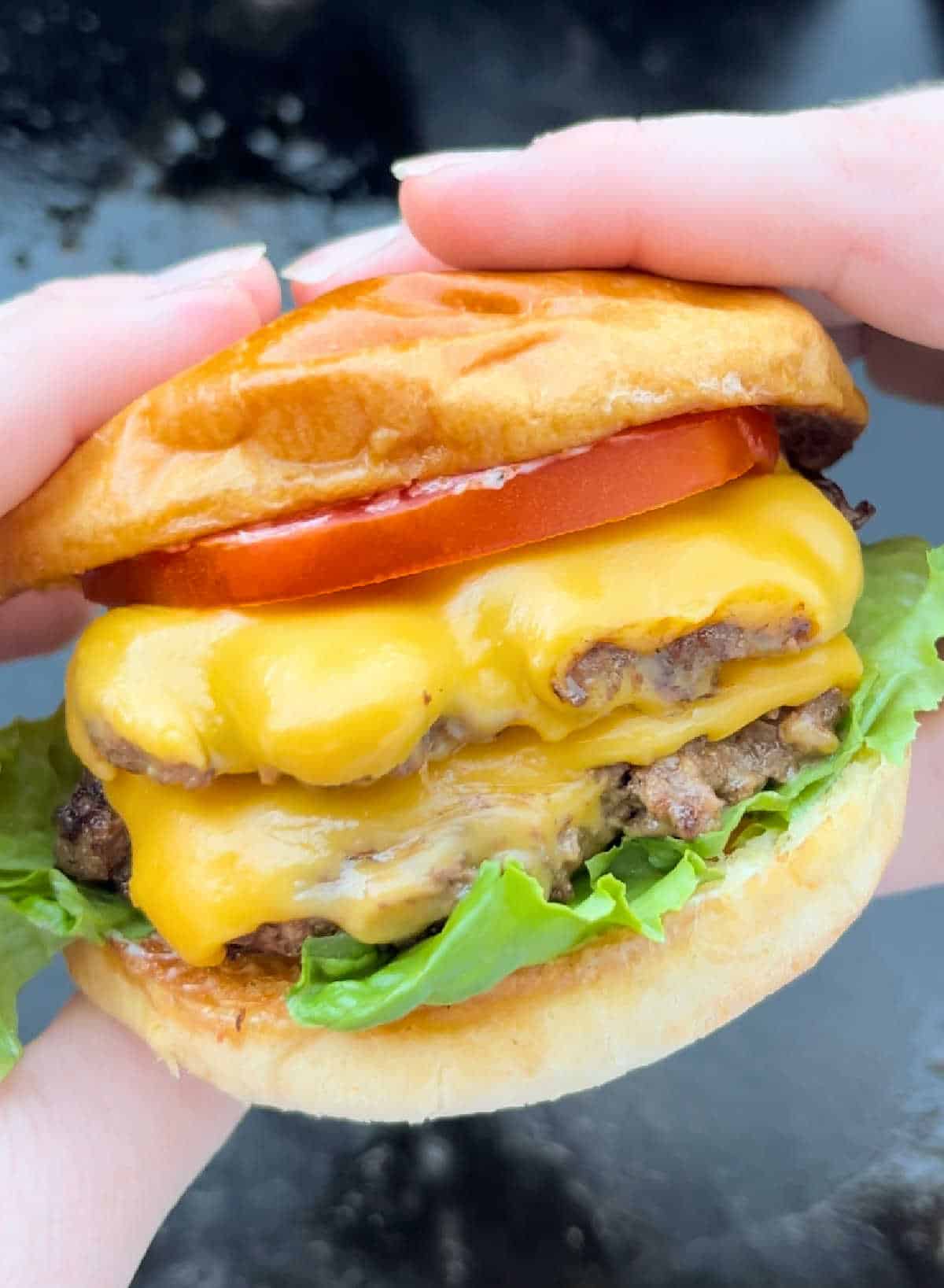 double smash burger with cheese in hand.