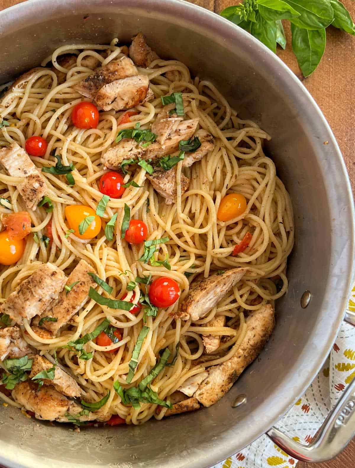 tomato basil pasta with grilled chicken in a large pot.
