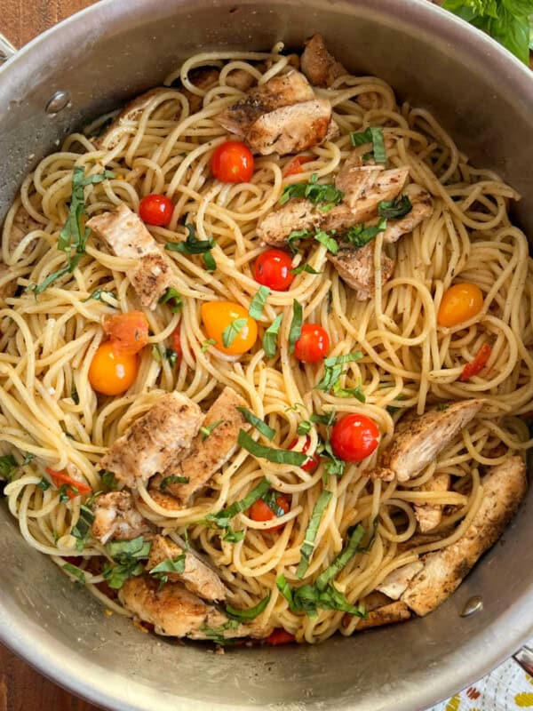 spaghetti with fresh tomatoes and basil and grilled chicken in a pot.