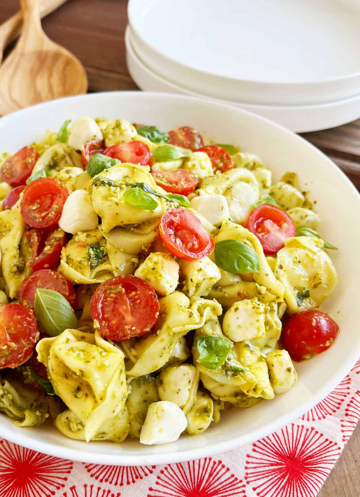 tortellini pesto pasta salad in serving bowl on table.