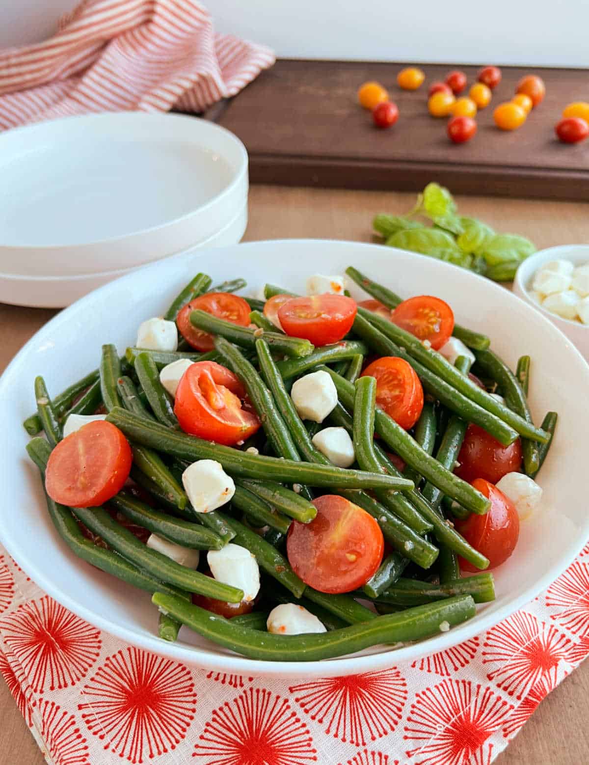 green bean salad with tomatoes and mozzarella on table.