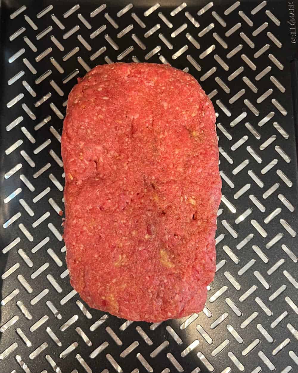 shaped loaf of ground beef on smoker tray.