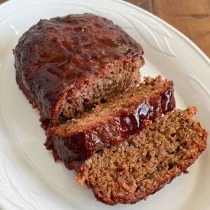 smoked meatloaf with bbq glaze on white platter.