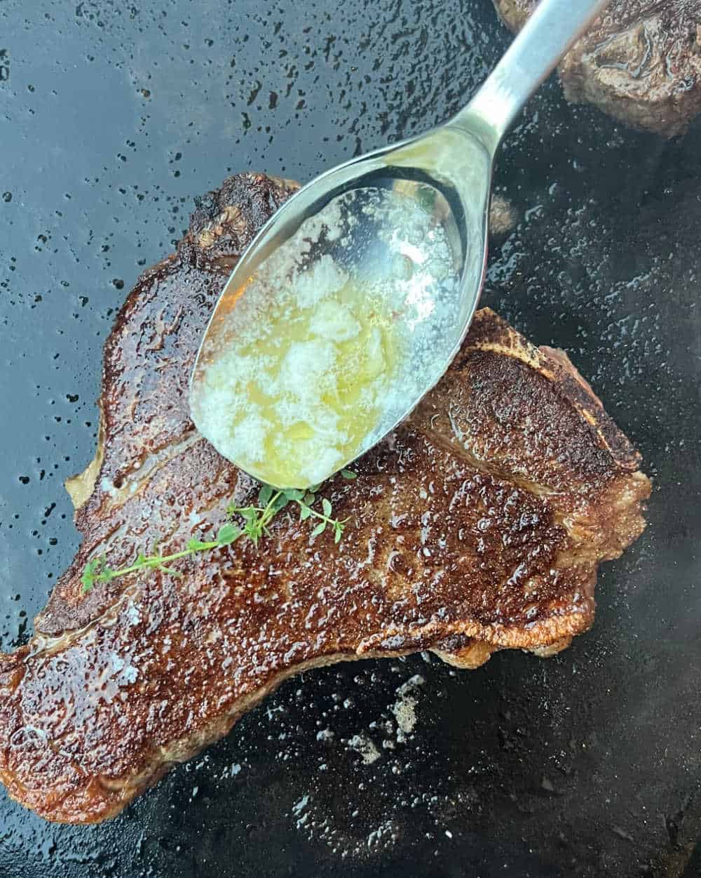 baste steaks with melted butter on griddle.