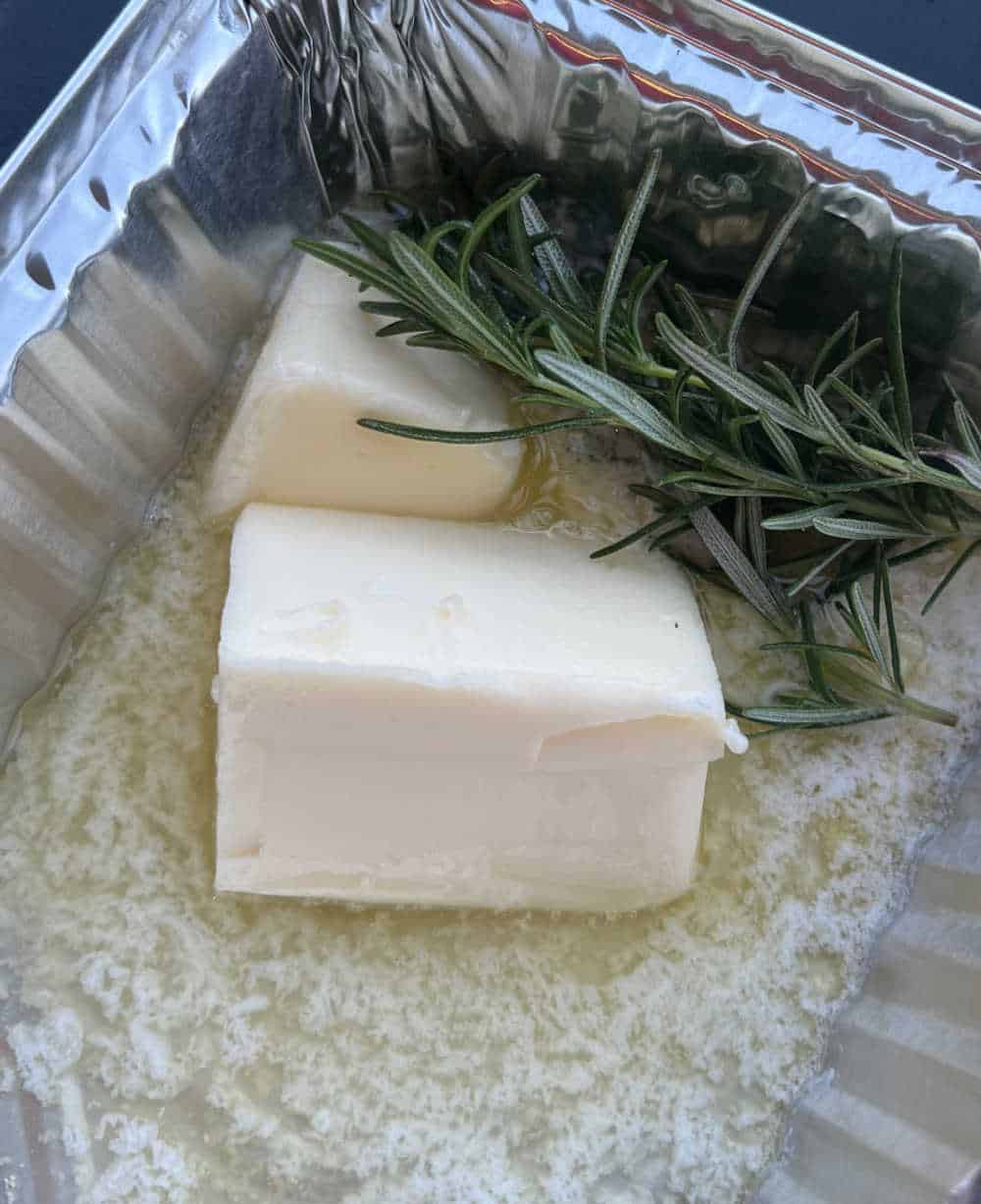 melt butter and garlic with fresh rosemary sprig on griddle.