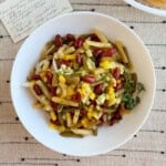 three bean salad in a white serving bowl with original recipe card.