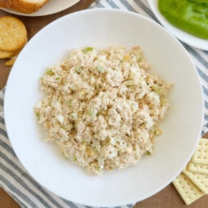 bowl of tuna salad with egg and celery on the table.