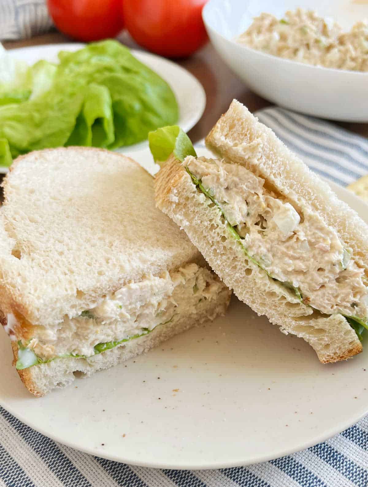 tuna salad sandwich on sourdough with lettuce and tomato.