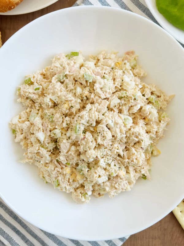 tuna salad with egg and celery in a white bowl.