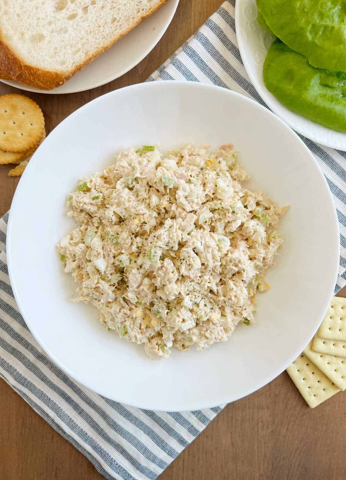 bowl of tuna salad with egg and celery on the table.