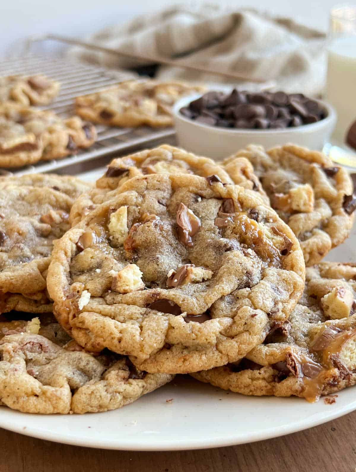 chocolate chip cookies with Twix bar pieces on plate.
