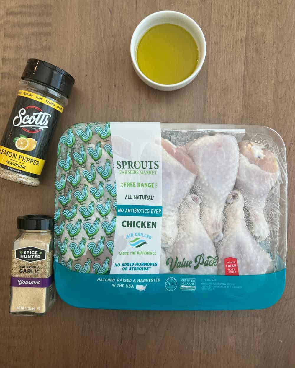 package of chicken legs, olive oil, garlic powder and lemon pepper seasoning.