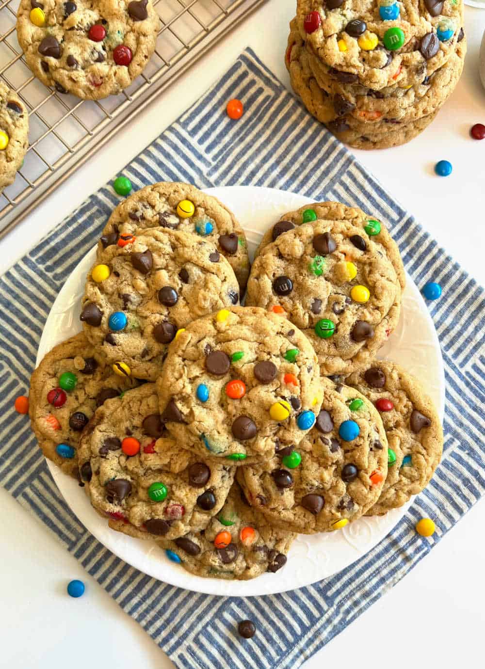 stacks of monster cookies on plate and table.