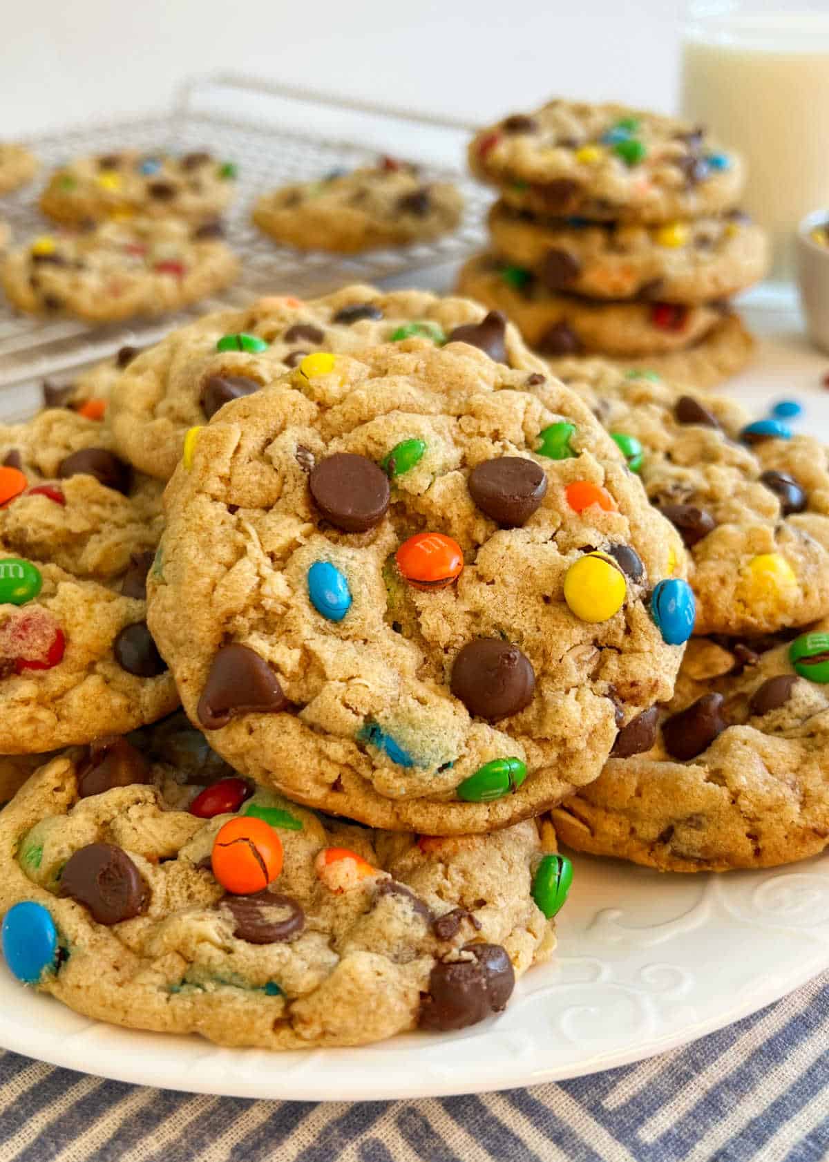 plate of monster cookies on the table with milk.