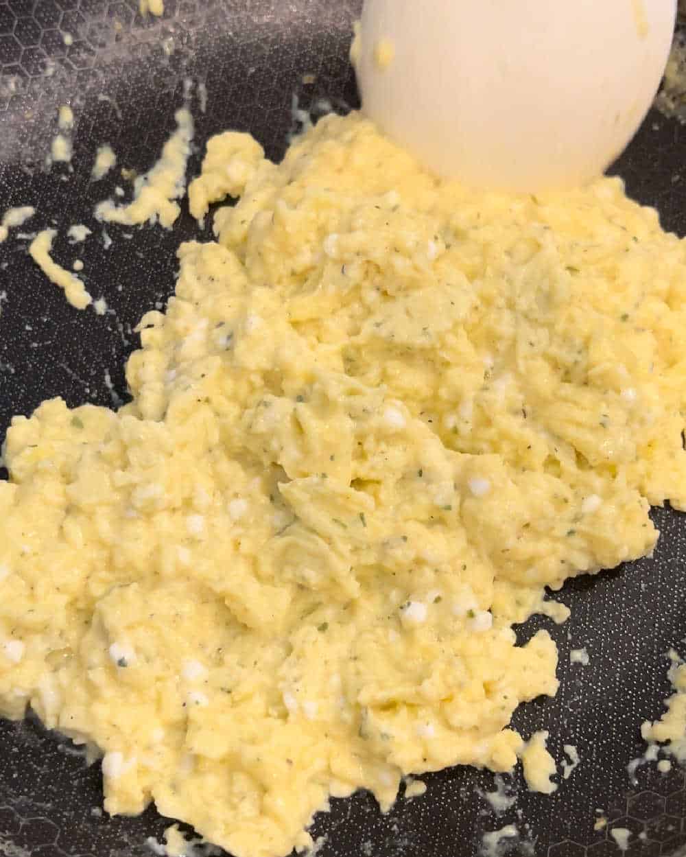 cooked scrambled eggs in skillet.