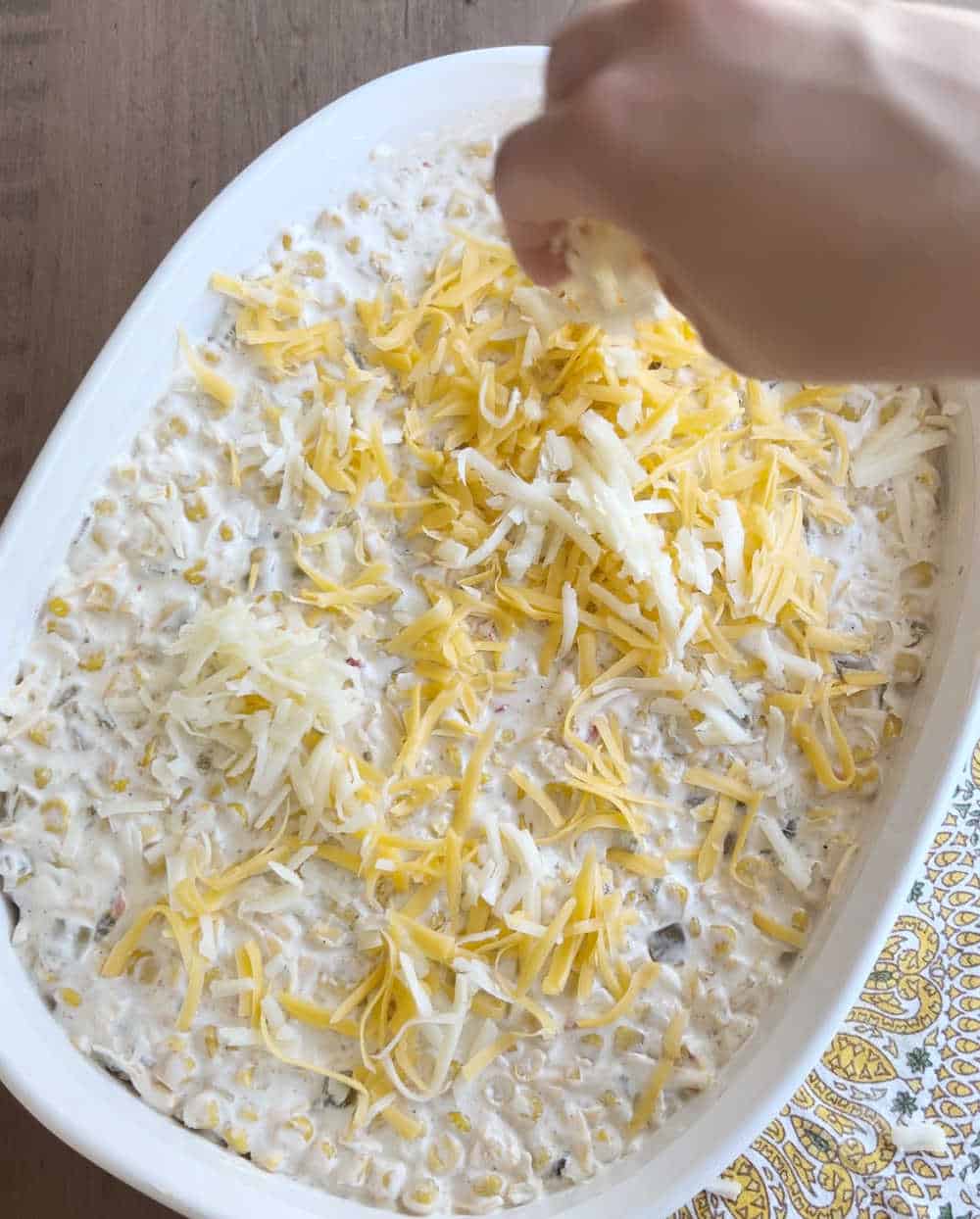 top dip with shredded cheese in casserole dish.