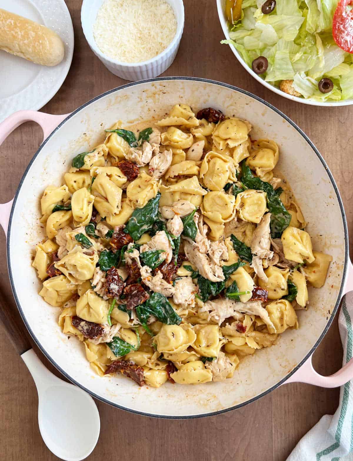 creamy chicken tortellini pasta in skillet on table.