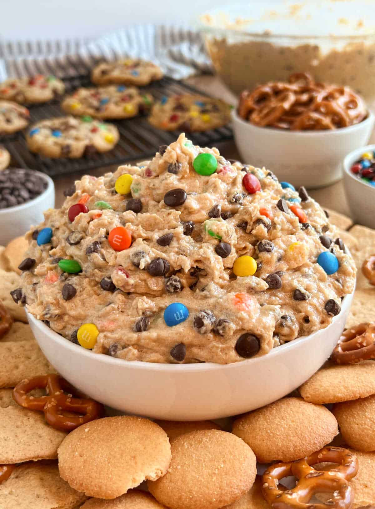 monster cookie dough dip in white bowl with dippers and cookies.