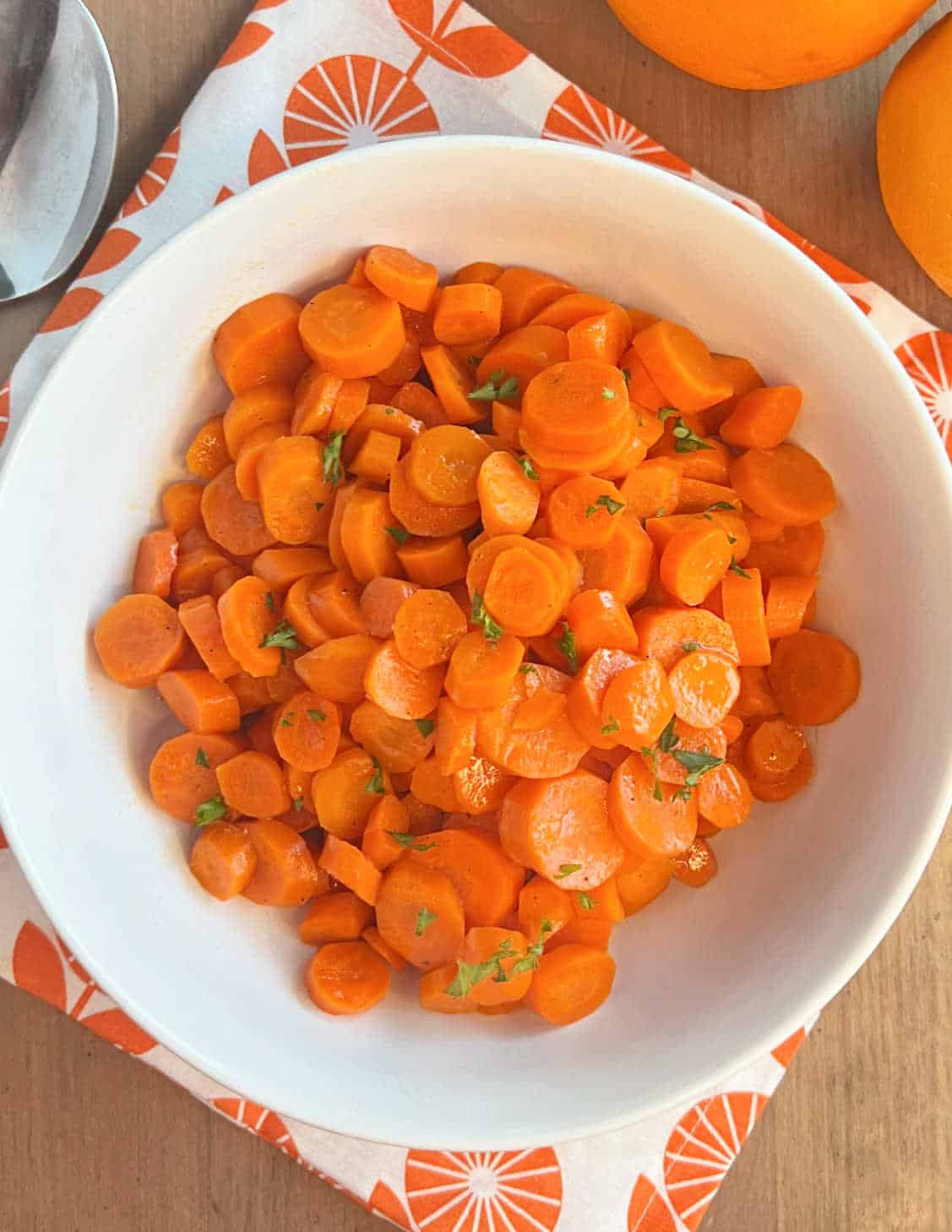 orange ginger glazed carrots in a white serving bowl.