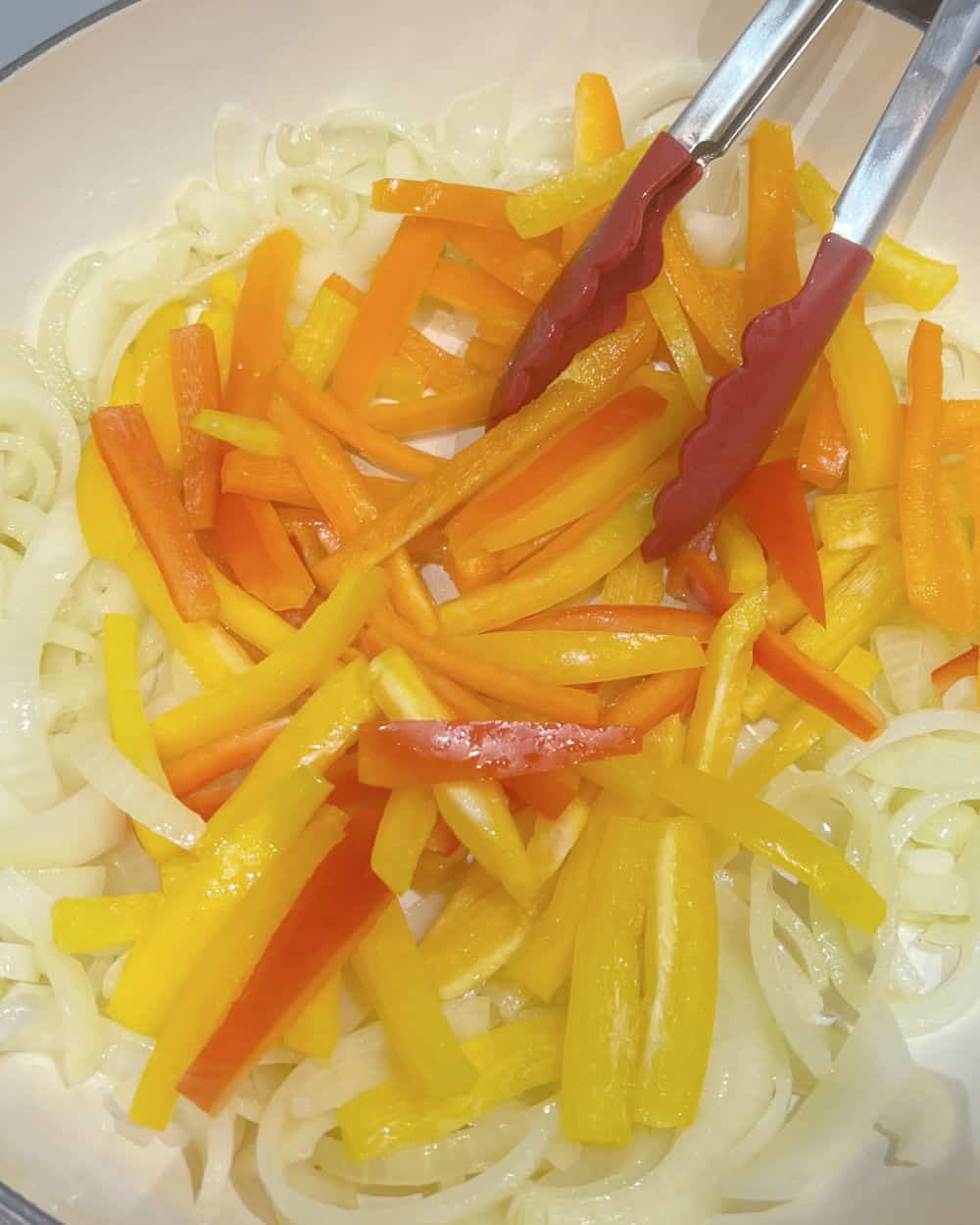 cook bell pepper strips with onion slices in skillet.