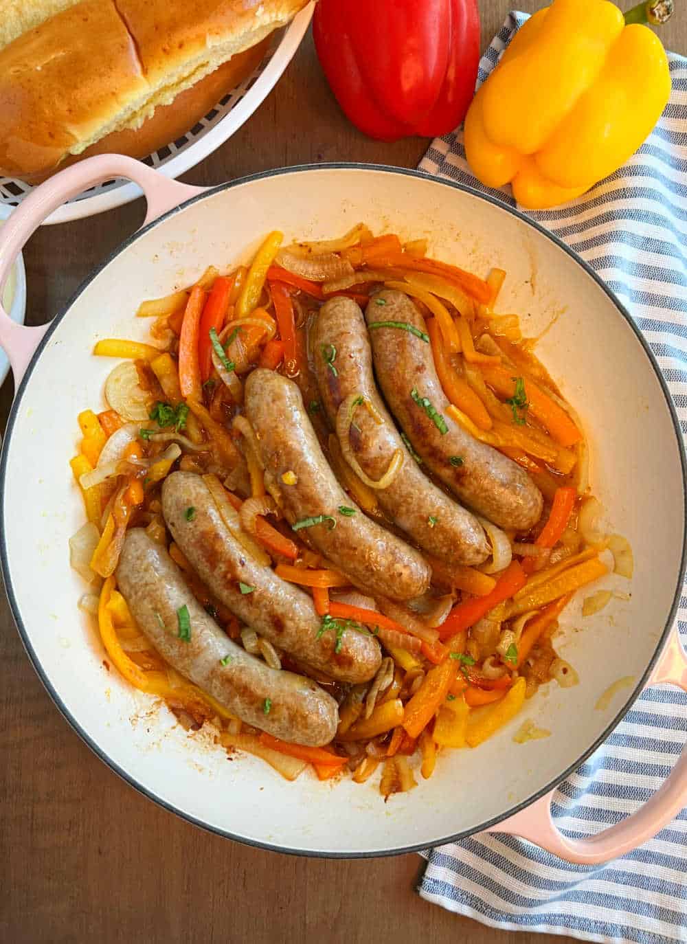 Italian sausage, peppers and onions in skillet on the table.