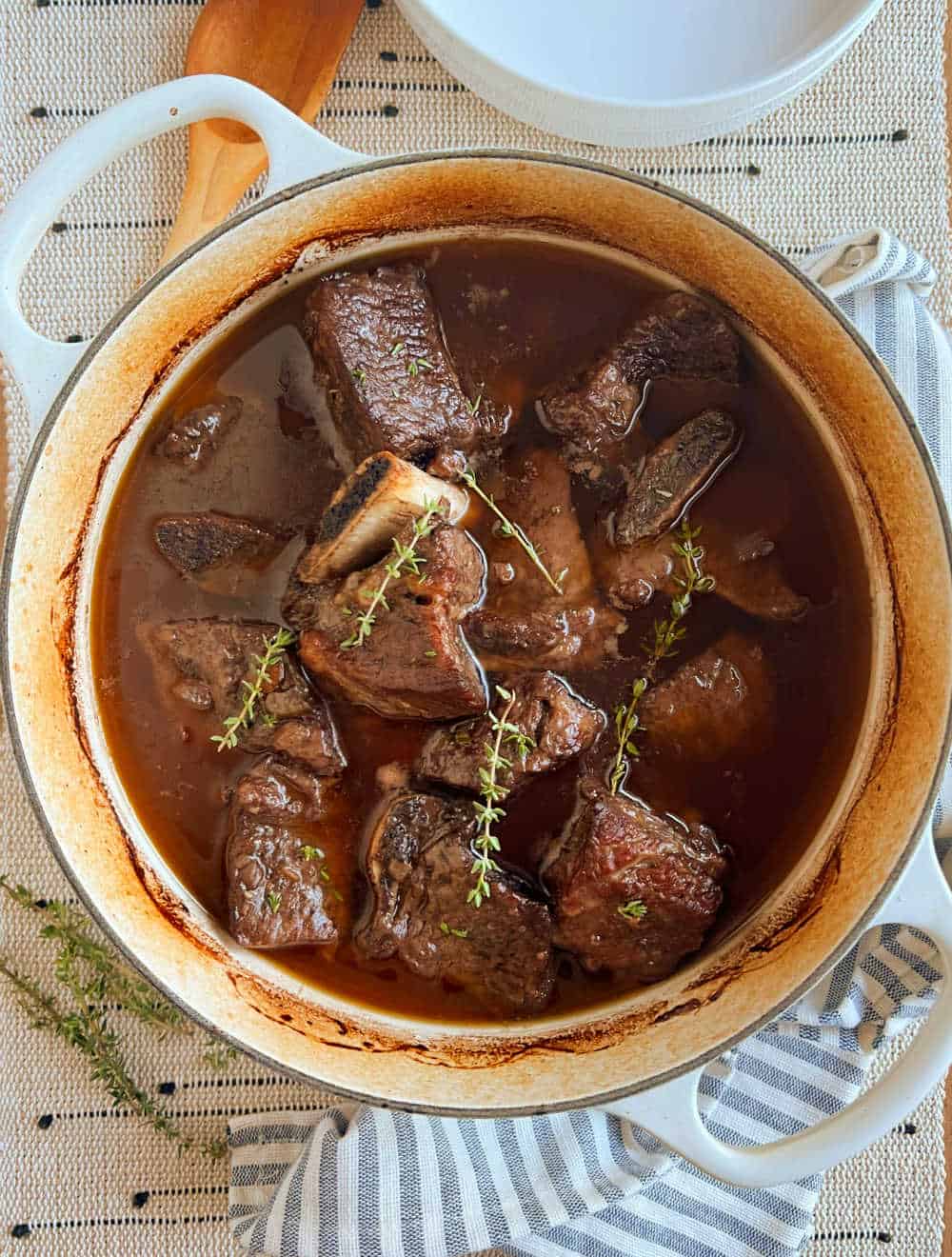 beef short ribs in dutch oven with fresh thyme.