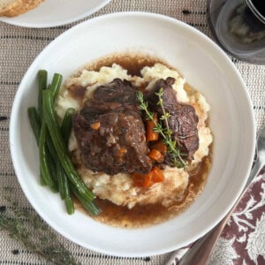 braised short ribs over mashed potatoes on plate.