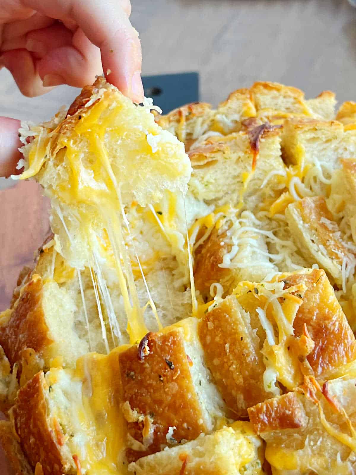 cheesy pull apart bread with garlic butter and stretchy mozzarella in hand.