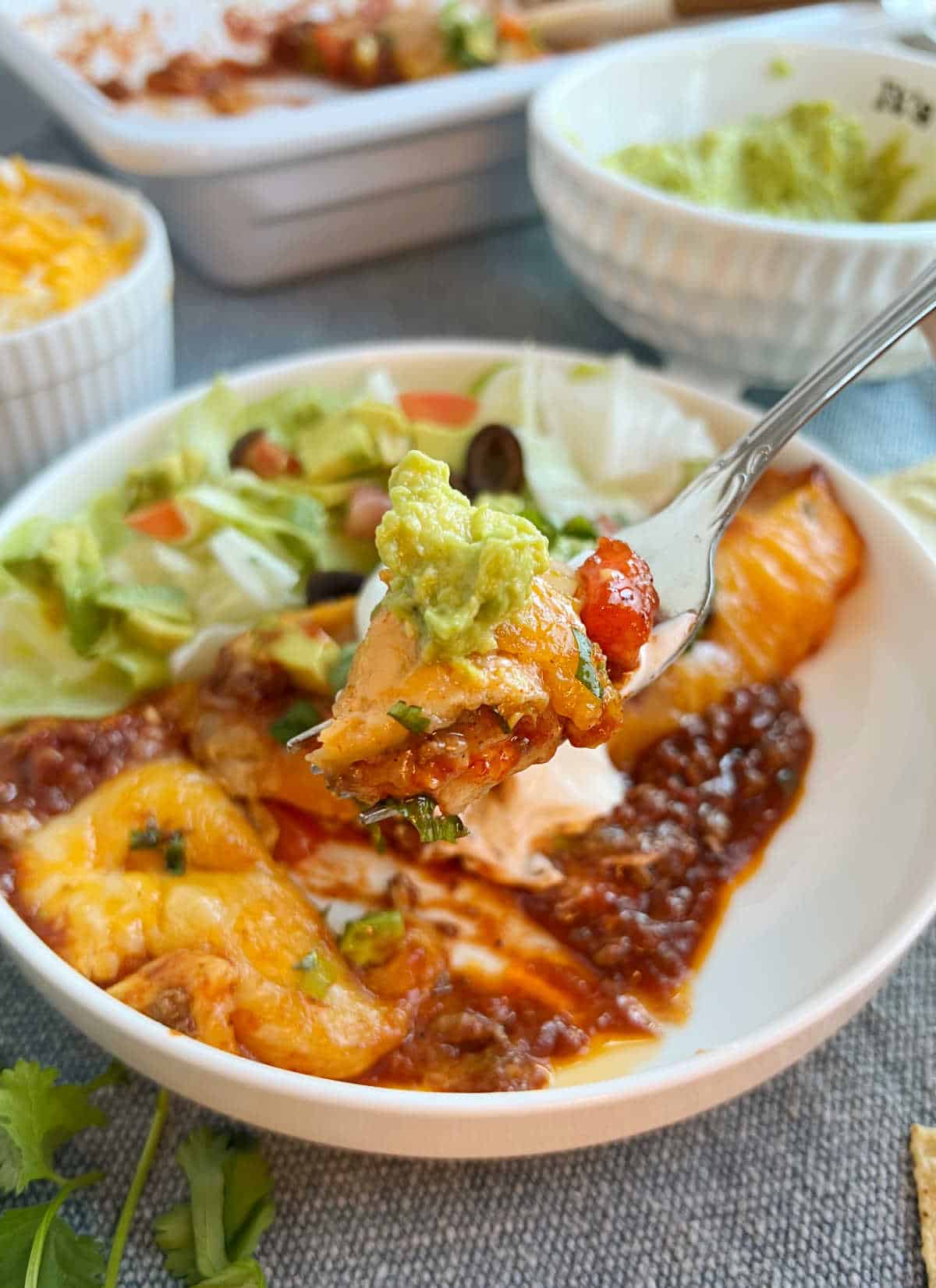 ground beef enchilada on fork with guacamole.