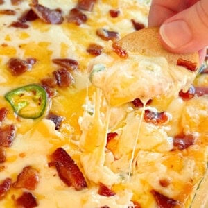 jalapeno popper dip with melty cheese and bacon on chip.