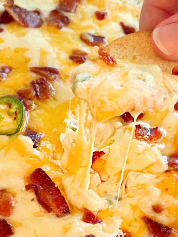 jalapeno popper dip with melty cheese and bacon on chip.