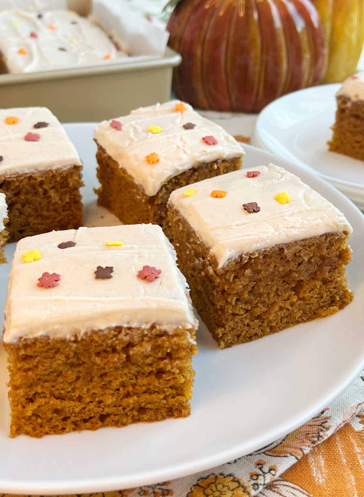 plate of frosted pumpkin bars on table.