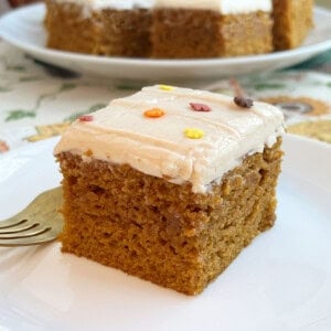 pumpkin bars with cream cheese frosting and fall sprinkles on plate with fork.