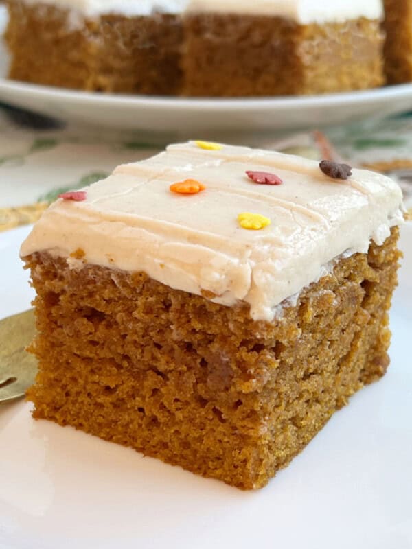 pumpkin bars with cream cheese frosting and fall sprinkles on plate with fork.