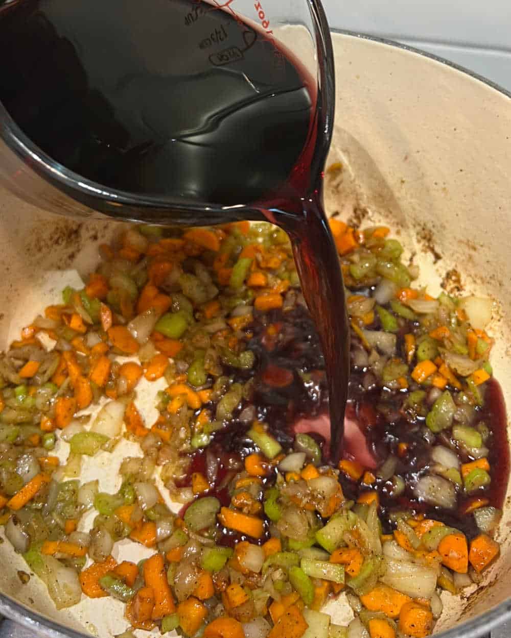 pour wine over vegetables in dutch oven.