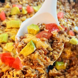 taco rice with ground beef and cheese in a serving spoon.