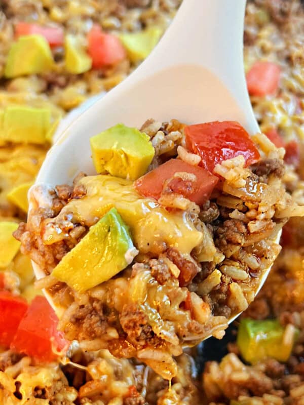 taco rice with ground beef and cheese in a serving spoon.