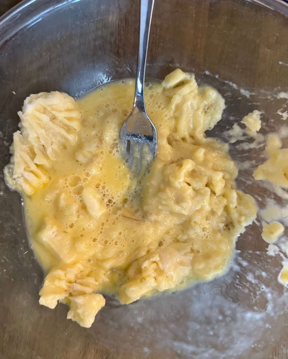 mash bananas and egg in bowl.