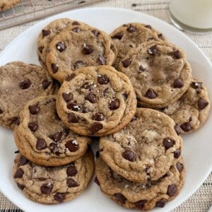 plate of chewy chocolate chip cookies with flaky salt on top.