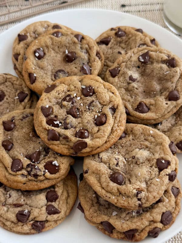 plate of chewy chocolate chip cookies with flaky salt on top.