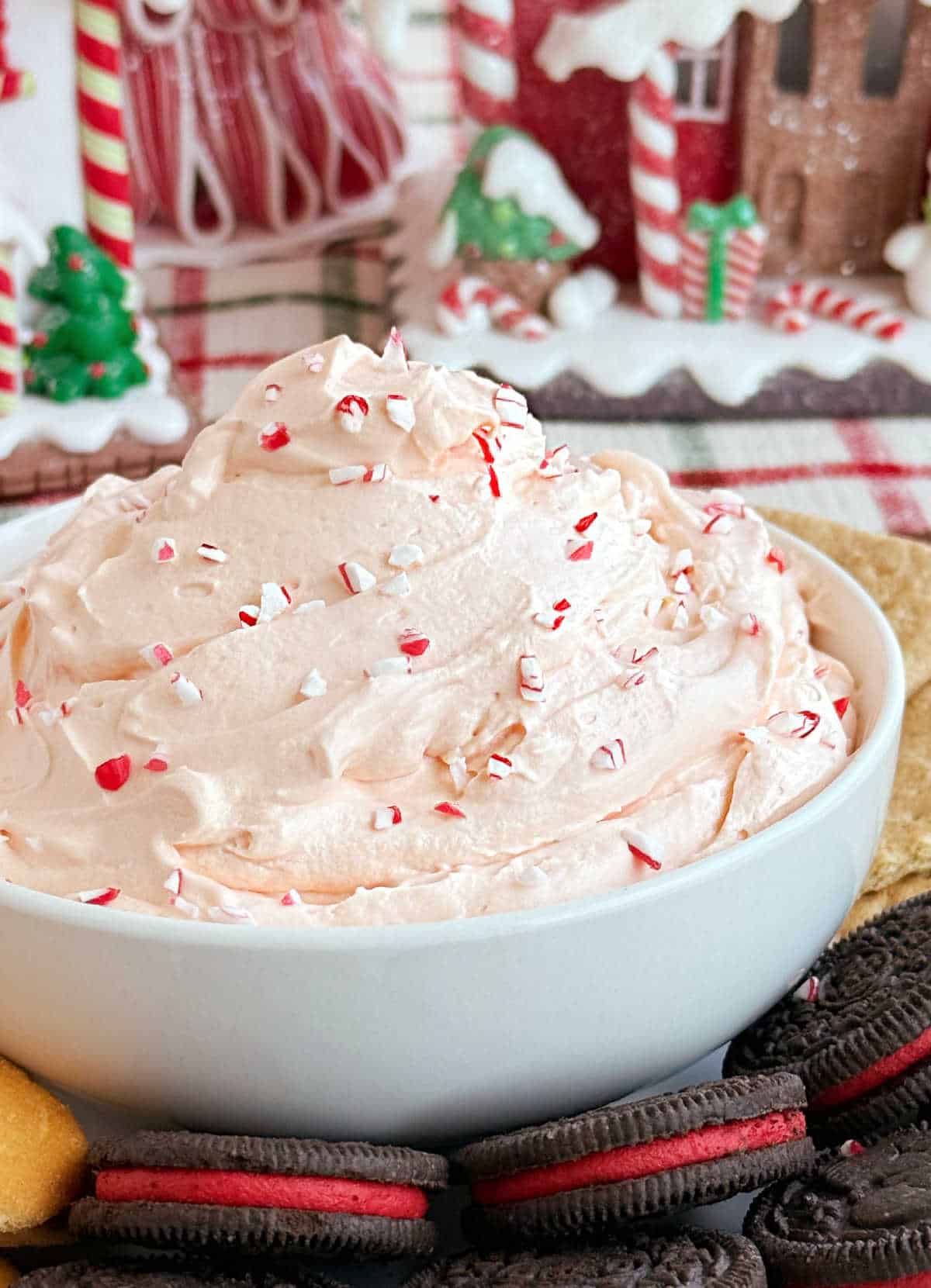 candy cane dip in white bowl with holiday dippers on tray.