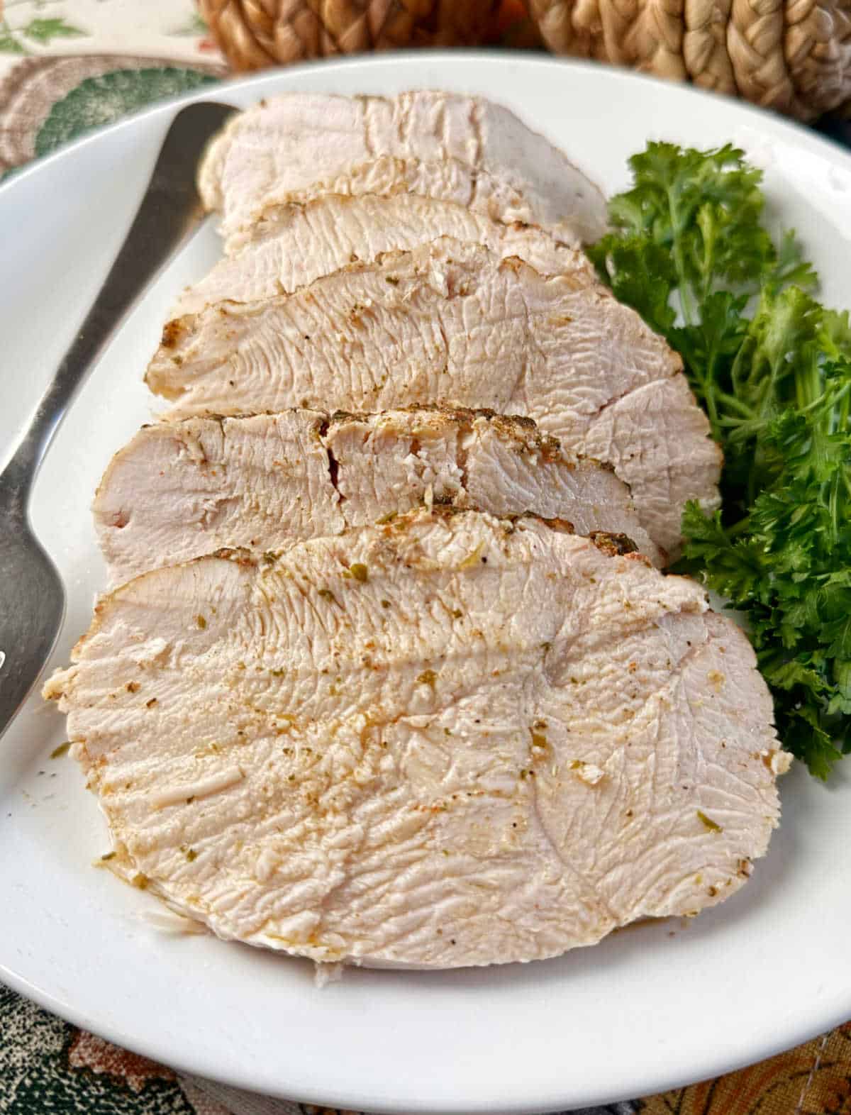 sliced turkey on platter with parsley.