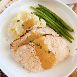 boneless crockpot turkey breast slices on plate.