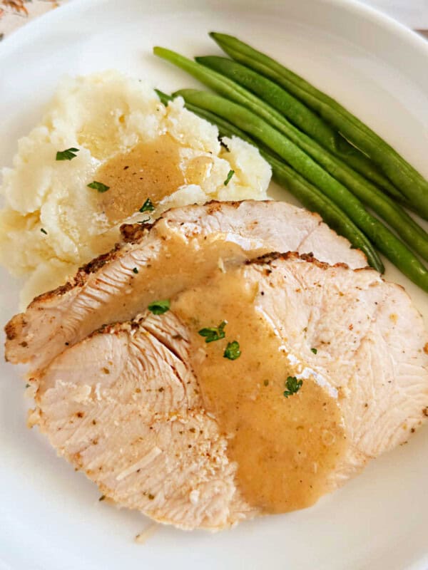 boneless crockpot turkey breast slices on plate.