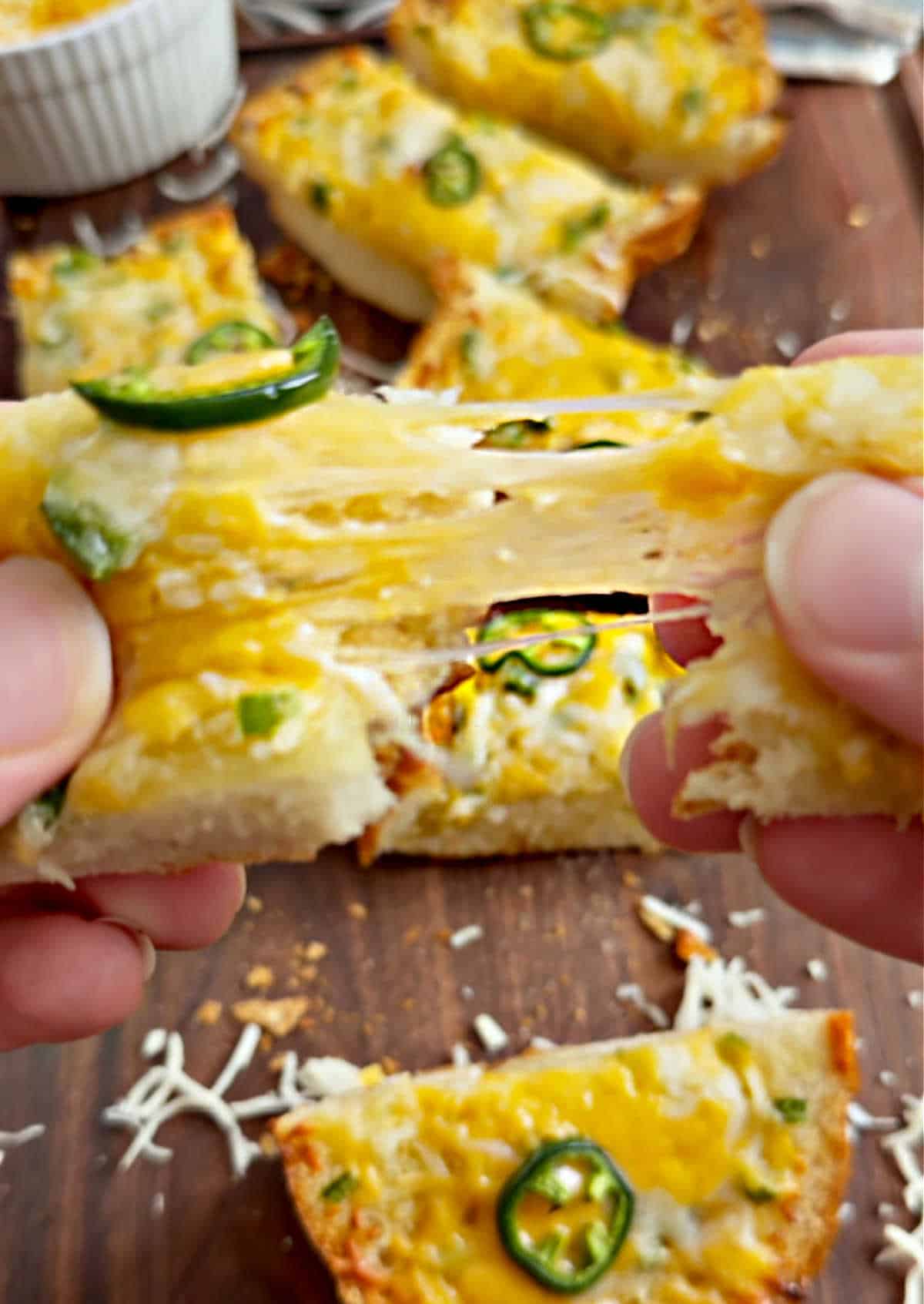 melty cheese pull of jalapeno garlic bread slice.